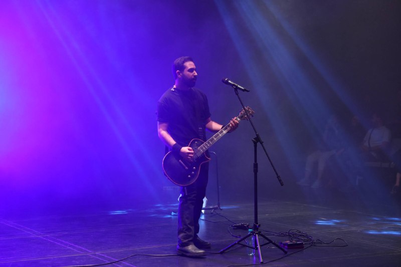 پایا هاشمیان در حال اجرای زنده گیتار در یک اجرای موسیقی