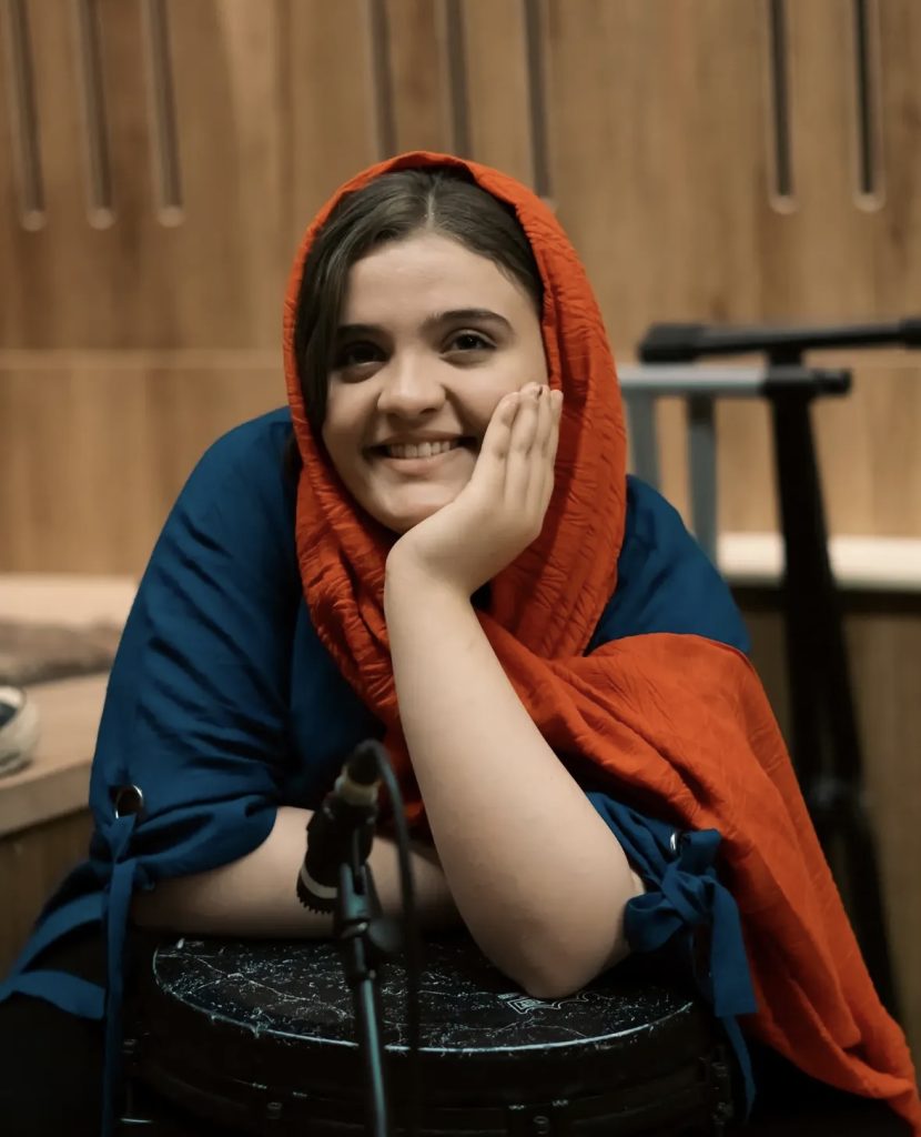 پارمیس موسوی مدرس هنگ‌درام و سازهای کوبه‌ای در کرج، نوازنده تنبک و دف، در نمای پرتره داخل فضای اجرای موسیقی